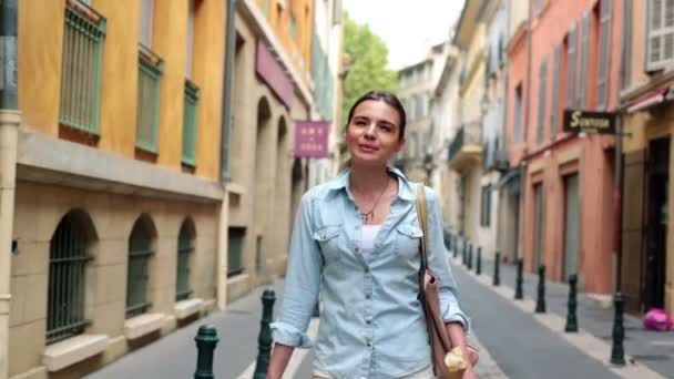 Woman walking and eating baguette - Filmati, video