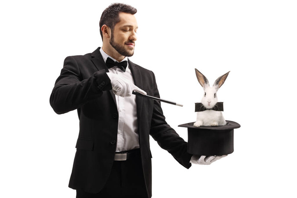 Magician oing a trick with a top hat and a rabbit isolated on white background - Photo, image