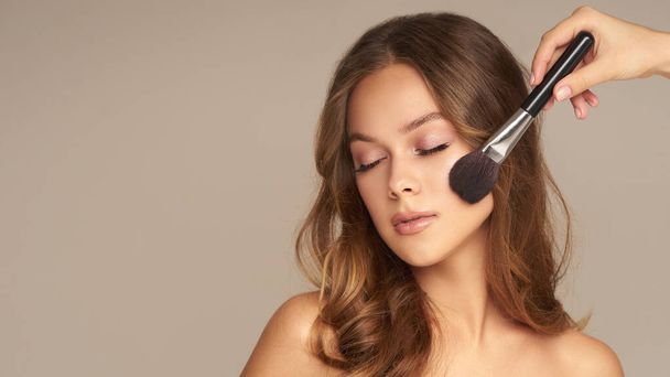 Beauty young woman with brushes on the grey background Close up portrait of brunette lifestyle cosmetic makeup  - Valokuva, kuva