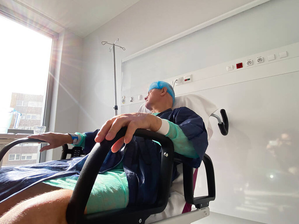 Enfeksiyon virüsü virüsü sonrası Fransa 'daki modern hastanede dinlenen bir erkek. - Fotoğraf, Görsel