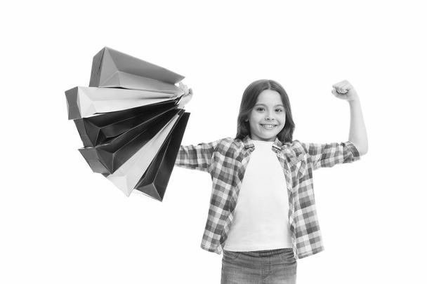 Einkaufen ist meine Supermacht. Glückliches Kind mit Papiertüten. Kleines Mädchen lächelt mit Einkaufstüten. Feiertagsvorbereitung und -feier. Shopping und Verkauf am Schwarzen Freitag. Saisonrabatt. Bachelor-Tag - Foto, Bild