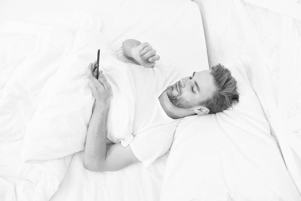 man use smartphone from the early morning. whole world in phone. he is blogging. flirting and sending text message. internet addiction and mobile abuse concept. man in bed chatting - Fotoğraf, Görsel