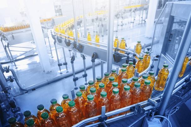 Завод напитков, Конвейерная лента с соком в бутылках, Промышленный интерьер в синий цвет, пищевые продукты и напитки производственной линии
 - Фото, изображение