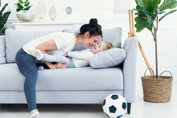mom and her daughter lying on the couch in the living room. - Foto, afbeelding