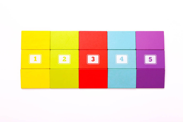 Цветные деревянные игрушечные блоки с цифрами на белой поверхности
 - Фото, изображение