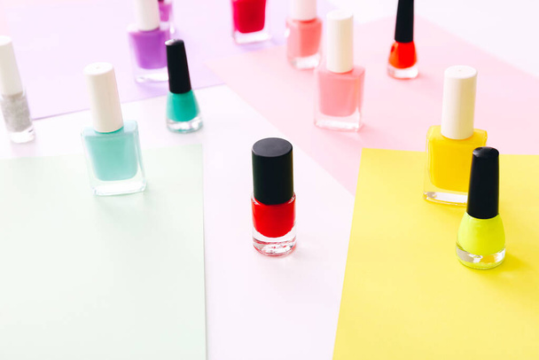 Group of nail polishes of different colors on colorful background. - Zdjęcie, obraz