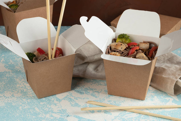 Οικολογική συσκευασία - noodles με λαχανικά, κοτόπουλο και κρέας σε βιοτεχνική συσκευασία για την υπηρεσία παράδοσης. Γρήγορο φαγητό. - Φωτογραφία, εικόνα