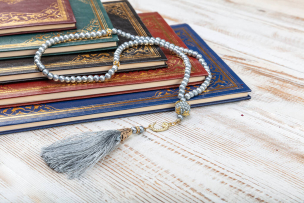 Pyhä Koraani arabialainen kalligrafia merkitys Koraanin ja tasbih tai rukousnauha helmiä yli puinen pöytä. Valikoiva painopiste ja sadon fragmentti. - Valokuva, kuva