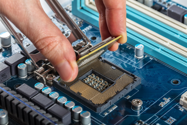 Computer technician installing CPU into motherboard. Close up. - Photo, Image