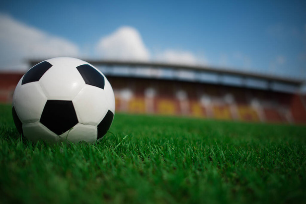 soccer ball on grass with stadium background - Foto, afbeelding