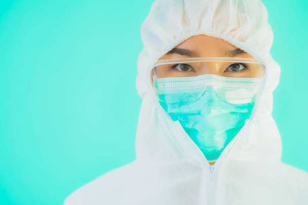 Retrato bonito jovem asiático médico mulher desgaste ppe ou equipamento de proteção individual para proteger de coronavírus ou covid19 em azul isolado fundo
 - Foto, Imagem