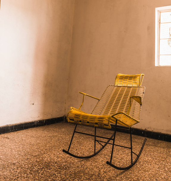 Sarı plastik hasır örülmüş sallanan sandalye. - Fotoğraf, Görsel