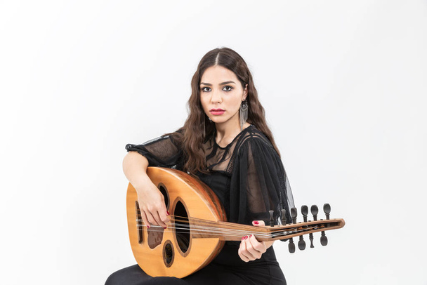 Oud playing woman. Young woman playing a lute string instrument isolated on white background - Photo, Image