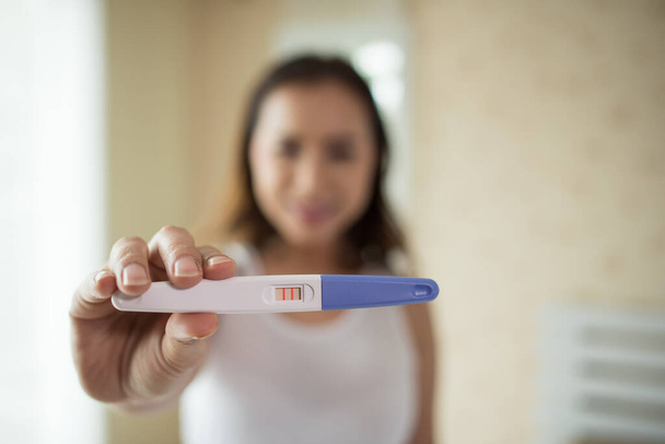 Young woman hand holding pregnancy test  - 写真・画像