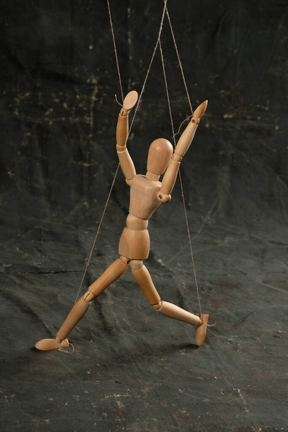 Puppet in the hands of puppeteer walks on isolated, background. Object on a texture background. - Fotó, kép