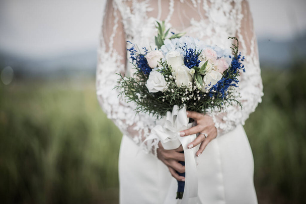 Novia mano sosteniendo flor en el día de la boda
 - Foto, Imagen