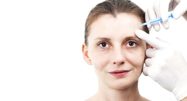 Woman getting botox injection to remove eye wrinkles - Photo, image