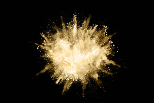 Golden powder explosion on black background. Freeze motion. - Photo, Image