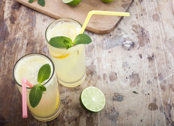 Limette fresche e limonata su fondo ligneo
 - Foto, immagini