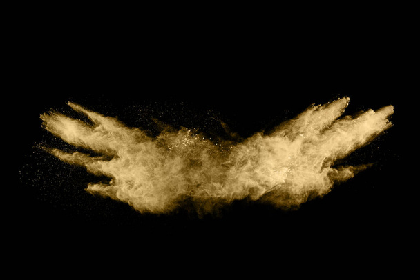 Golden powder explosion on black background. Freeze motion. - Photo, Image