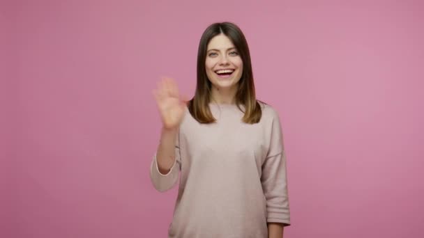 Hearing loss. Positive woman communicating with deaf-mute sign language, making fingers shape saying nonverbal phrase Hi, how are you? I'm fine thanks. indoor studio shot isolated on pink background - Imágenes, Vídeo