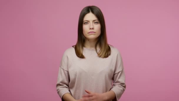 Hey you, be careful! Brunette young woman with dispraising look, scolding with admonishing finger gesture and warning of danger, showing disapproval sign. studio shot isolated on pink background - 映像、動画