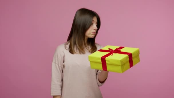 Beautiful cheerful brunette woman opening gift box and smiling joyfully, looking amazed satisfied with nice present, unexpected birthday surprise. indoor studio shot isolated on pink background - Imágenes, Vídeo