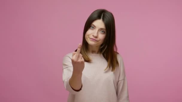 Rude vulgar woman showing around middle fingers and looking with sarcastic expression, demonstrating protest and negativity, rejecting with hate. indoor studio shot isolated on pink background - Imágenes, Vídeo