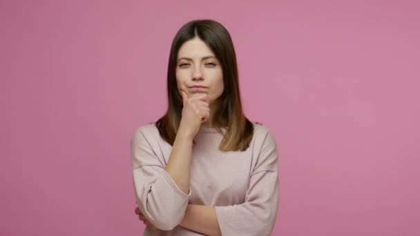 Clever brunette woman considering serious plan, solving problem in mind and nodding approvingly, thinking over smart idea, pondering and musing answer. indoor studio shot isolated on pink background - Metraje, vídeo
