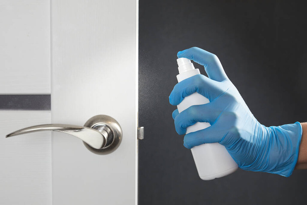 Female hands disinfect, clean and wash of door handles. Prevention of coronavirus infection during the COVID-19. White door. - Foto, Imagen