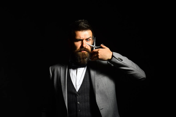Macho in formal suit has his beard and moustache cut. - 写真・画像
