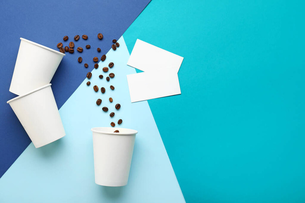 Tasses à café à emporter avec cartes de visite sur fond de couleur - Photo, image