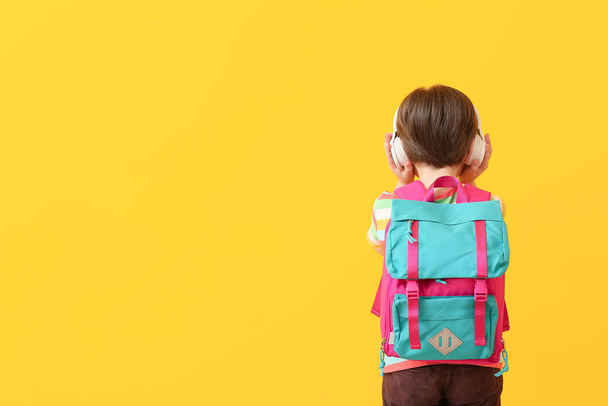Aranyos kis iskolás hallgat zenét a színes háttér - Fotó, kép