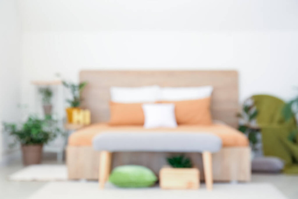 Big bed and bench in interior of modern room, blurred view - Foto, Imagem