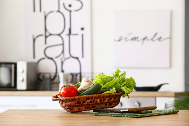 Mand met verse groenten op keukentafel - Foto, afbeelding