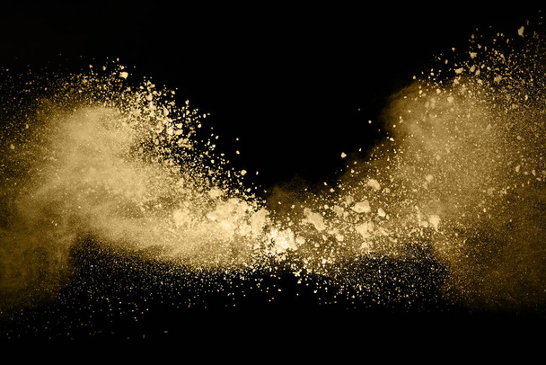 Golden powder explosion on black background. Freeze motion. - Fotó, kép