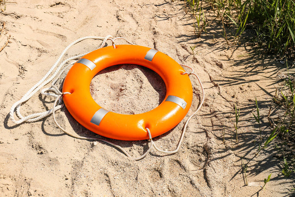 Bright lifebuoy ring on beach - Zdjęcie, obraz