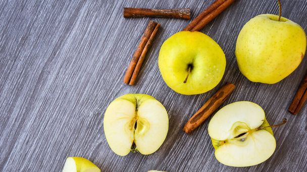 緑の黄金のリンゴや木の背景にシナモンスティックとグラニースミス,料理を準備,デザート,健康的な栄養,秋の時間 - 写真・画像