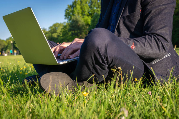 Kültéri számítógép. Diákfiú, aki laptopon dolgozik, táblagép a nyári parkban. ember személy üzleti természet kívül az online technológia. Elektronikus eszközök távoktatási koncepciója. - Fotó, kép