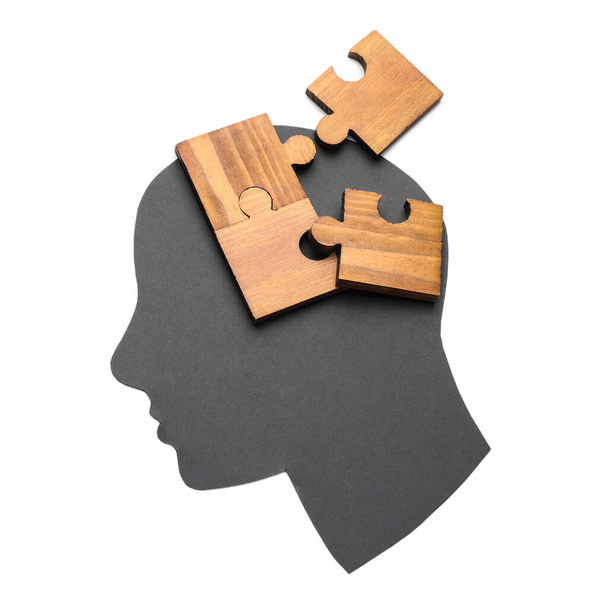 Papel cabeça humana e peças de quebra-cabeça em fundo branco. Conceito de demência
 - Foto, Imagem