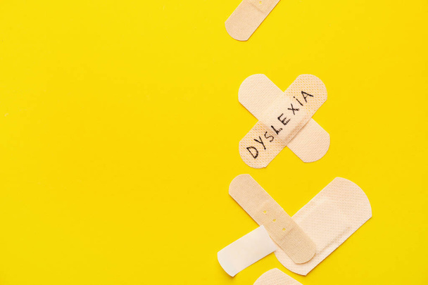 Ιατρικά έμπλαστρα με τη λέξη DYSLEXIA στο φόντο χρώματος - Φωτογραφία, εικόνα