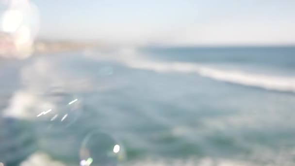 Burbujas de jabón en el muelle en California, fondo borroso en bucle sin costuras durante el verano. Metáfora romántica creativa, concepto de ensueño, felicidad y magia. Símbolo abstracto de infancia, fantasía, libertad - Metraje, vídeo