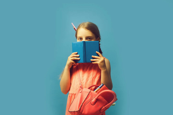 Pupil with braids, isolated on blue background. Back to school - Фото, зображення