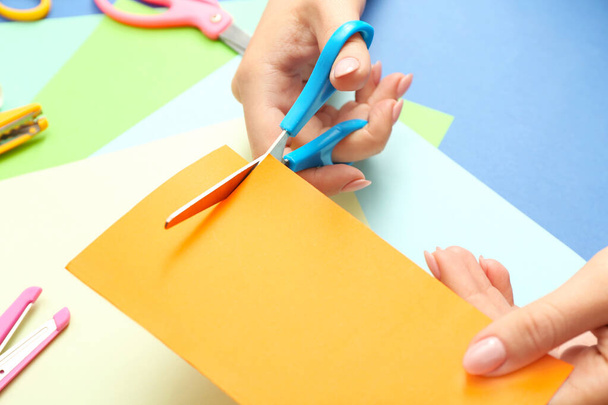 Женщина с ножницами резки бумаги на цветном фоне
 - Фото, изображение
