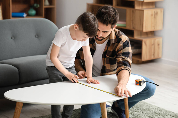 Pai e filho com tomar medidas de mesa em casa
 - Foto, Imagem