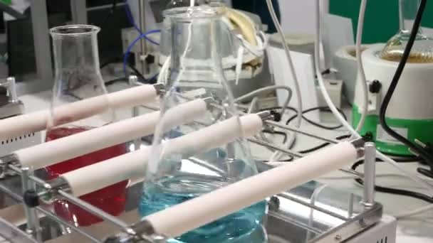 Vloeibare reagentia in glazen reageerbuiskolven Medische farmaceutische laboratoriumapparatuur. Vaccin en drugsonderzoek, diagnostiek en analyse, experiment tijdens Covid-19 of Corona virus pandemie concept - Video