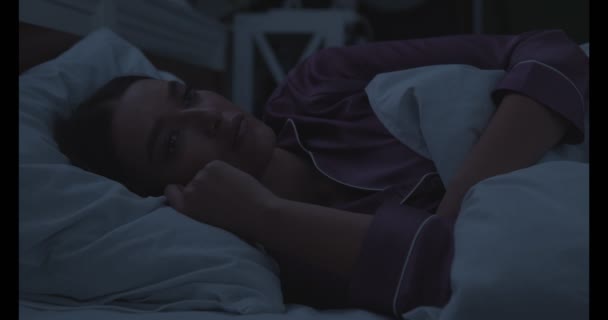 Γυναίκα τη νύχτα που υποφέρει από αϋπνία στο κρεβάτι - Πλάνα, βίντεο