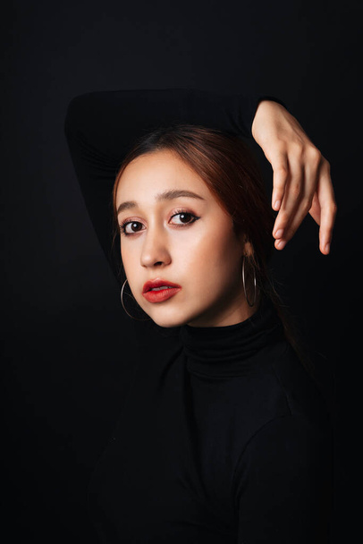 Close up portrait of pretty beautiful young woman wearing black sweater isolate over dark background. - Fotó, kép