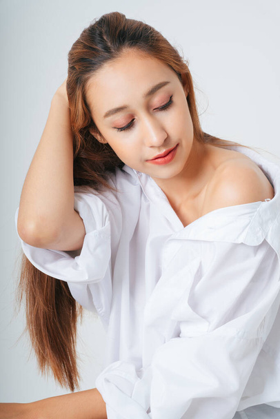 Mooie vrouw in wit shirt met natuurlijke make-up geïsoleerd over witte achtergrond. Huidverzorgingsconcept. - Foto, afbeelding