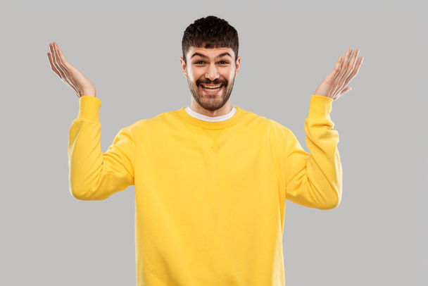 smiling young man in yellow sweatshirt - 写真・画像